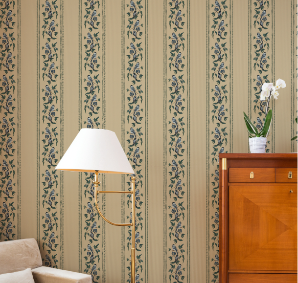 Living room with beige sofa, wooden cabinet, and lamp against striped wallpaper.
