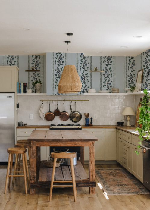 Kitchen with wooden table, stools, and decorative elements.