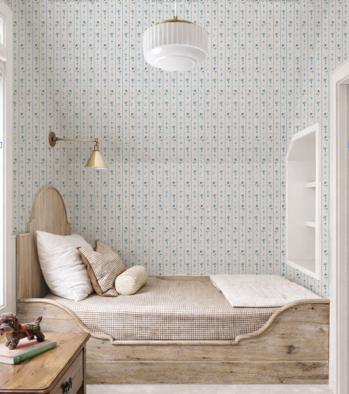 Children's bedroom with wooden bed, patterned wallpaper, and small desk.