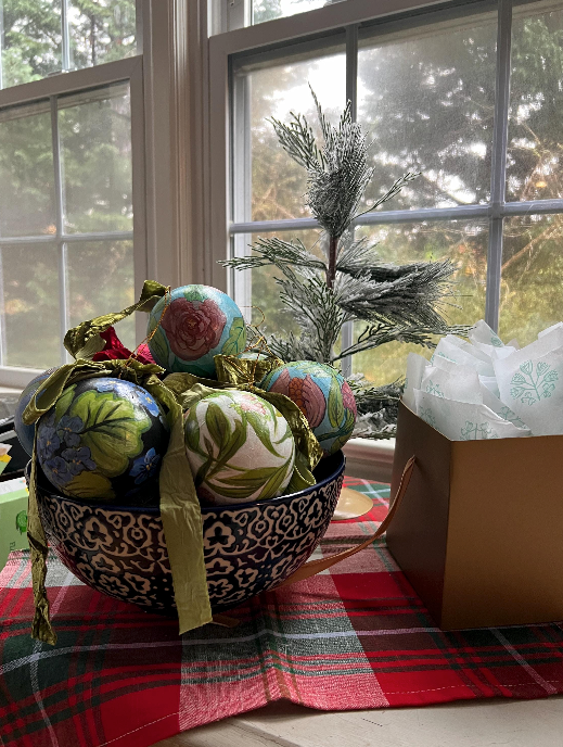 Decorative bowl with colorful balls on a table in front of a window