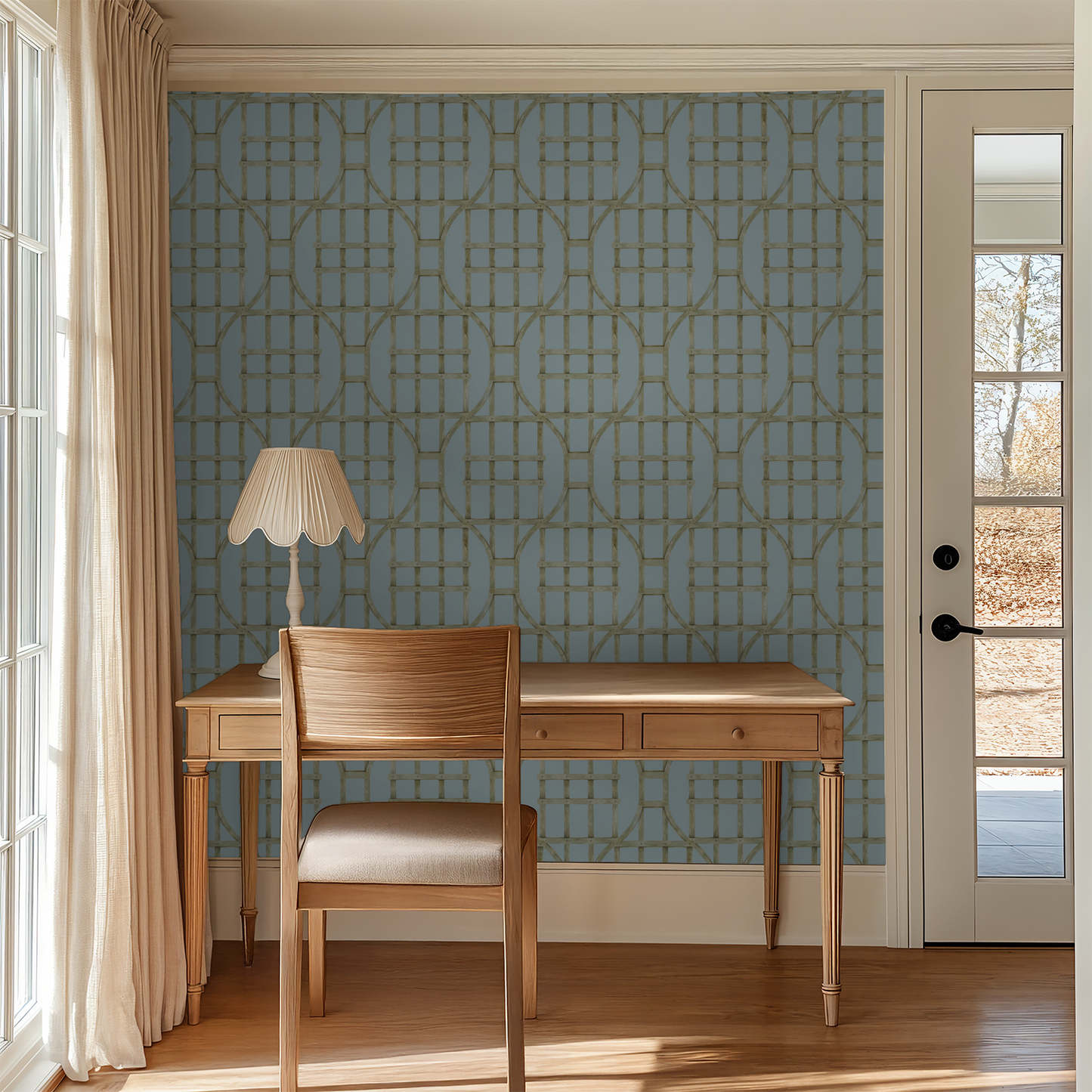 Soft blue trellis wallpaper with green lattice in a sunlit room with wooden desk and chair.