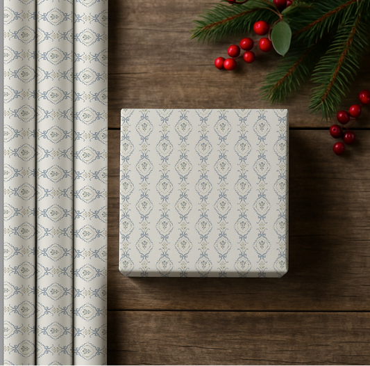 Patterned gift wrap roll and box on a wooden surface with Christmas decorations.