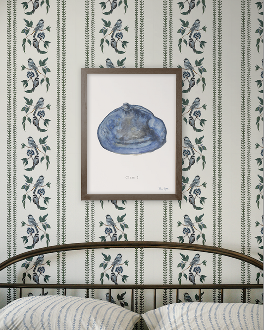 Framed artwork of a blue shell on a wall with decorative floral pattern