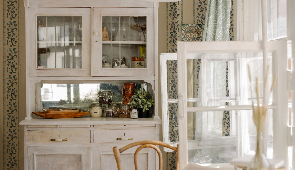 Vintage-style room with a large white cabinet, decorative items, and a chair.