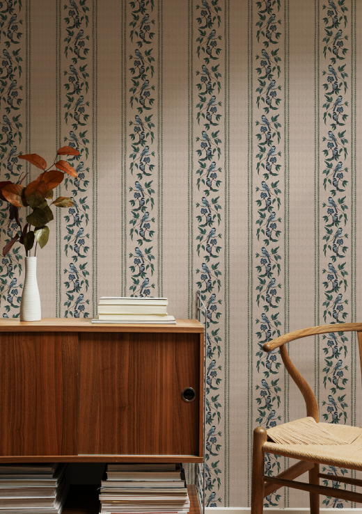 Wooden cabinet and chair against a patterned wallpaper wall