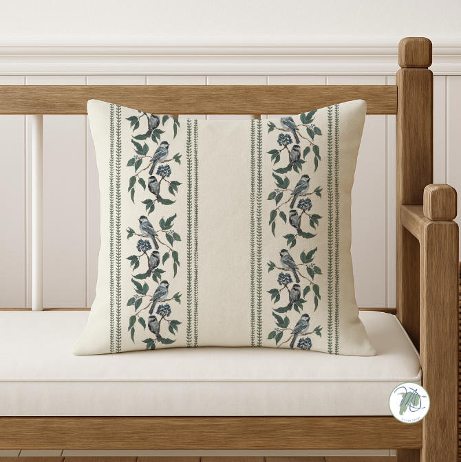 Decorative pillow with bird and floral pattern on a wooden bench