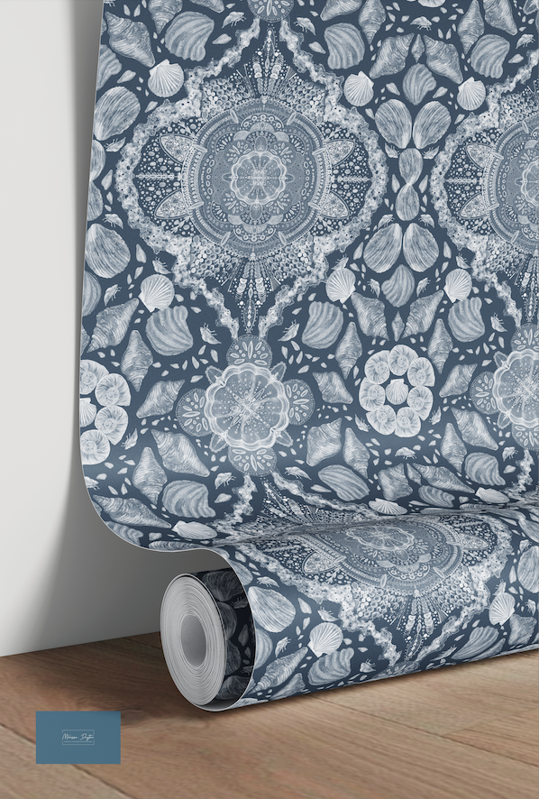 Roll of wallpaper with a blue and white floral pattern on a wooden floor.