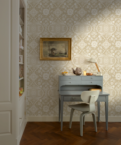 Room interior with a desk, chair, and decorative wall art against a patterned wallpaper.