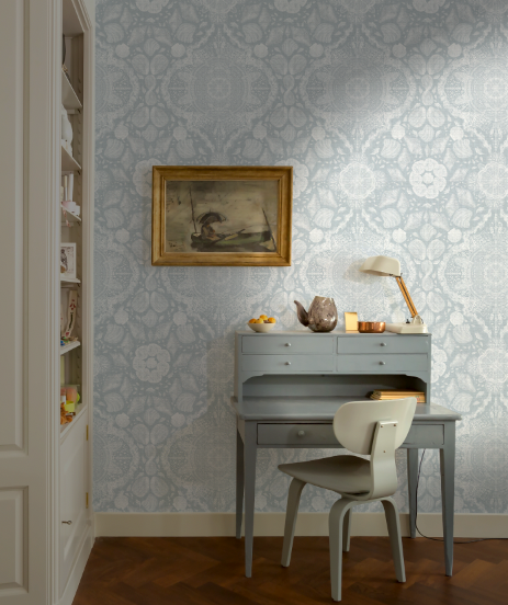 Room interior with a desk, chair, and decorative wall paper.