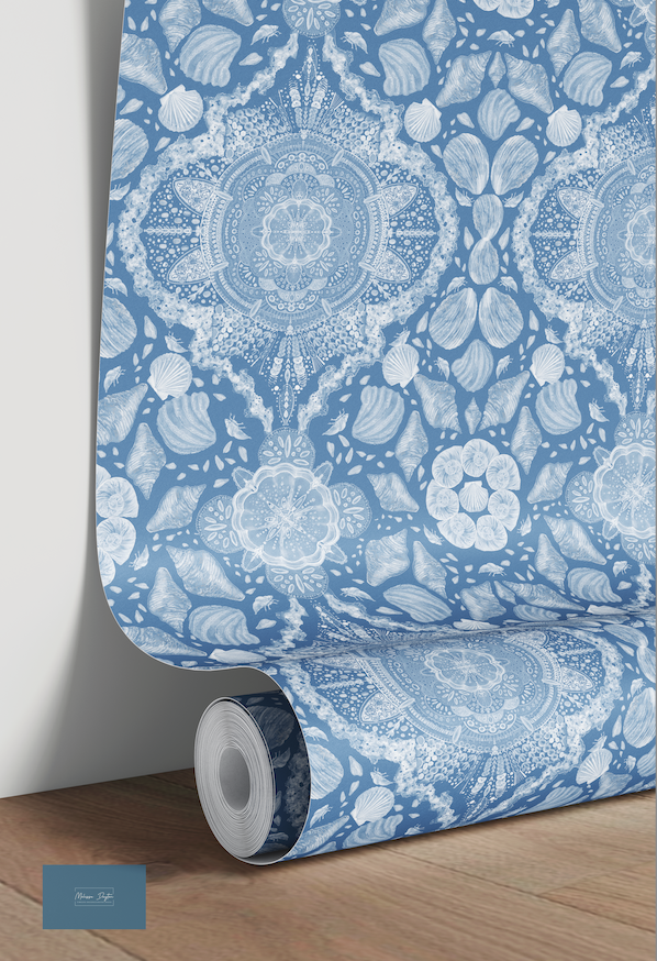 Roll of blue and white patterned wallpaper on a wooden floor.