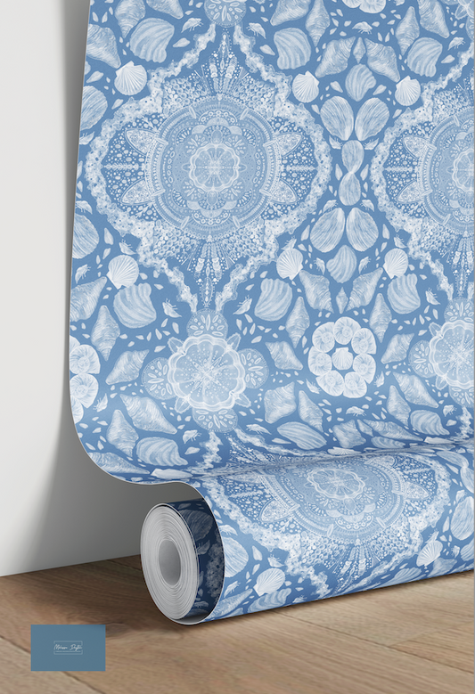 Roll of blue and white patterned wallpaper on a wooden floor.