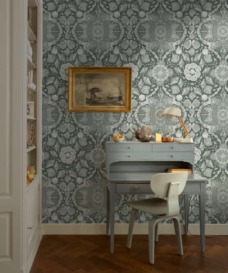 Room interior with patterned wallpaper, desk, and chair.