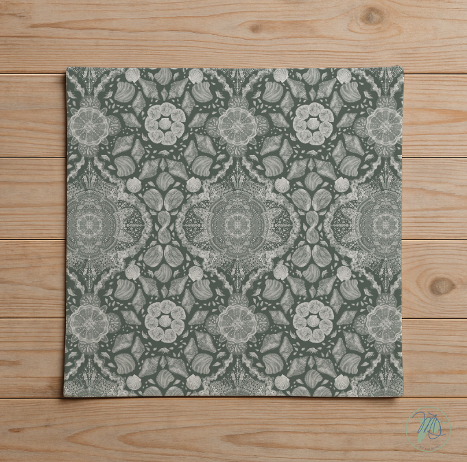 Decorative square tile with a floral pattern on a wooden surface