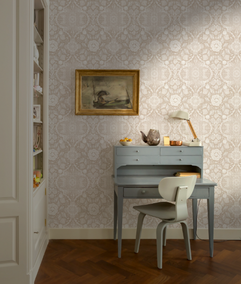 Room interior with a desk, chair, and decorative items against a patterned wall.