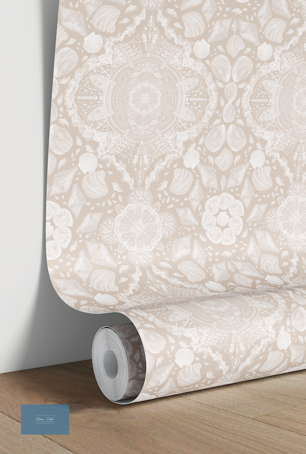 Roll of beige floral wallpaper on a wooden surface with a white wall background.