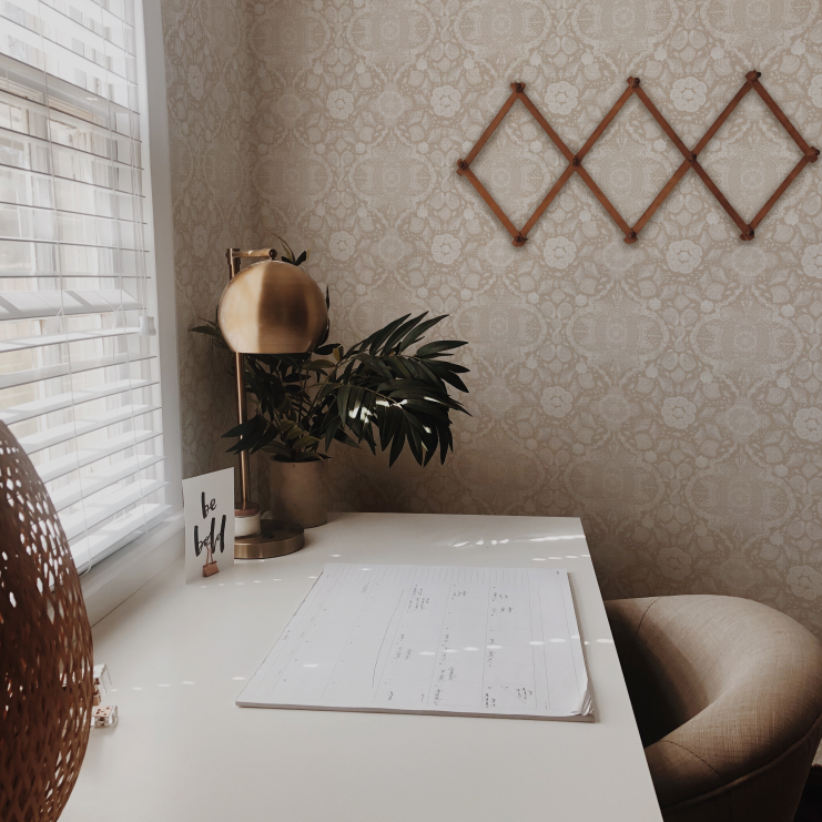 Home office with a desk, plant, and decorative elements.