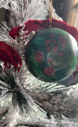 Decorative Christmas ornament with floral design on a tree branch