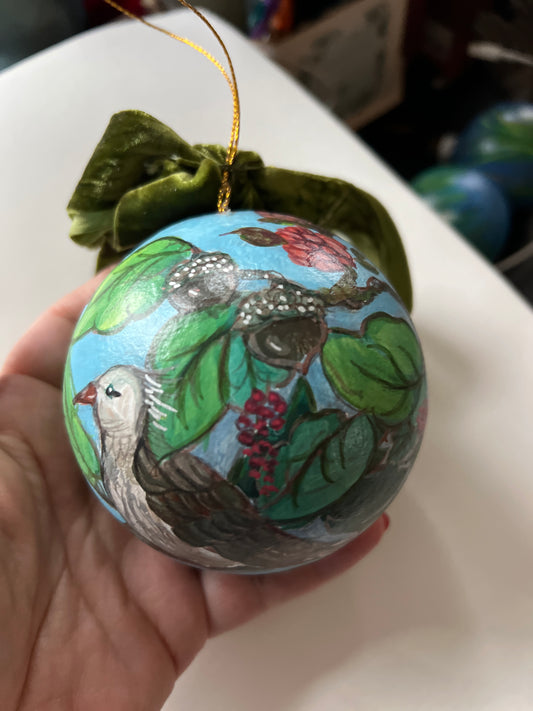 Decorative ornament with birds and leaves held by a hand