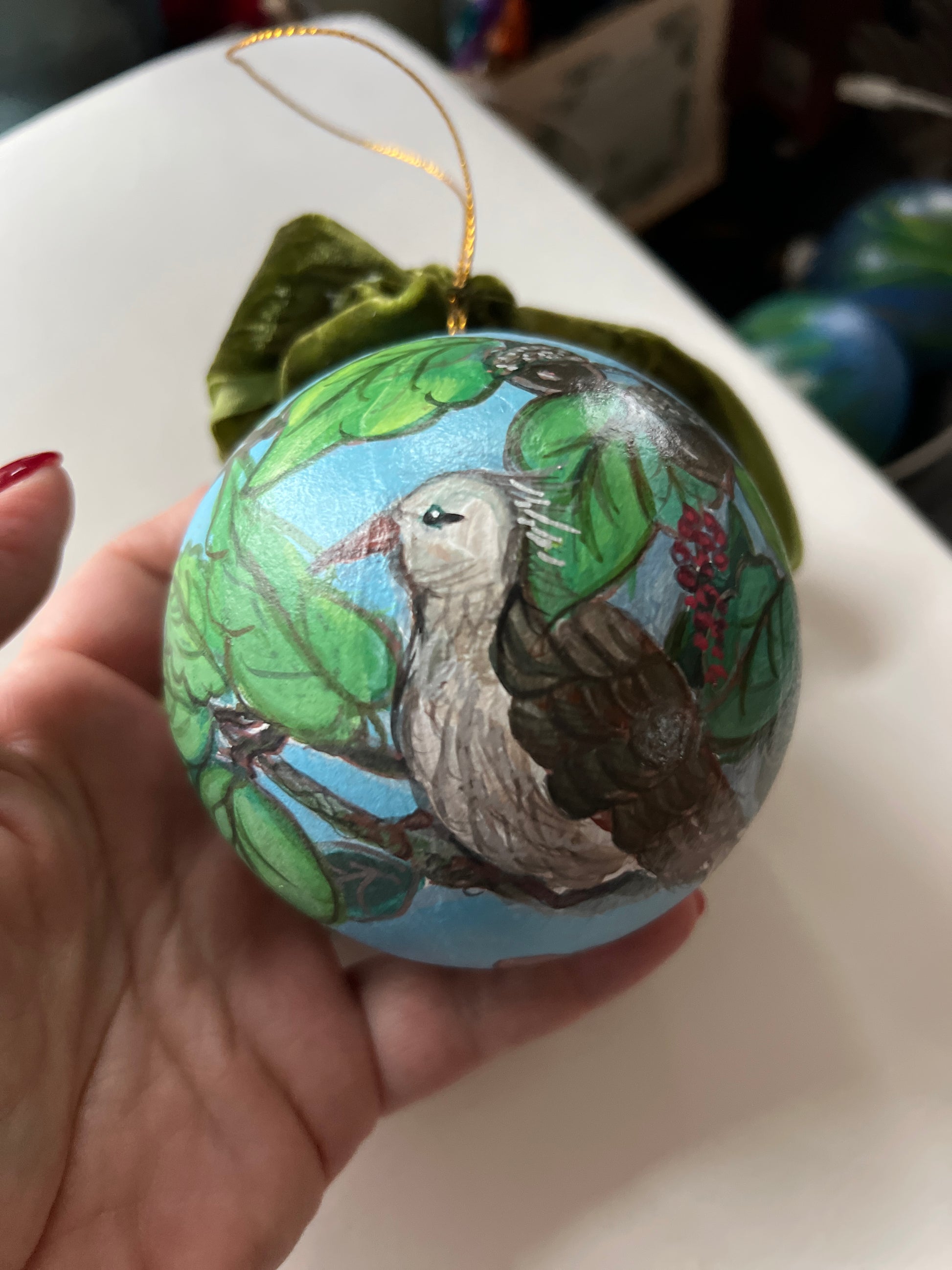 Decorative ornament with bird and nest design held by a hand