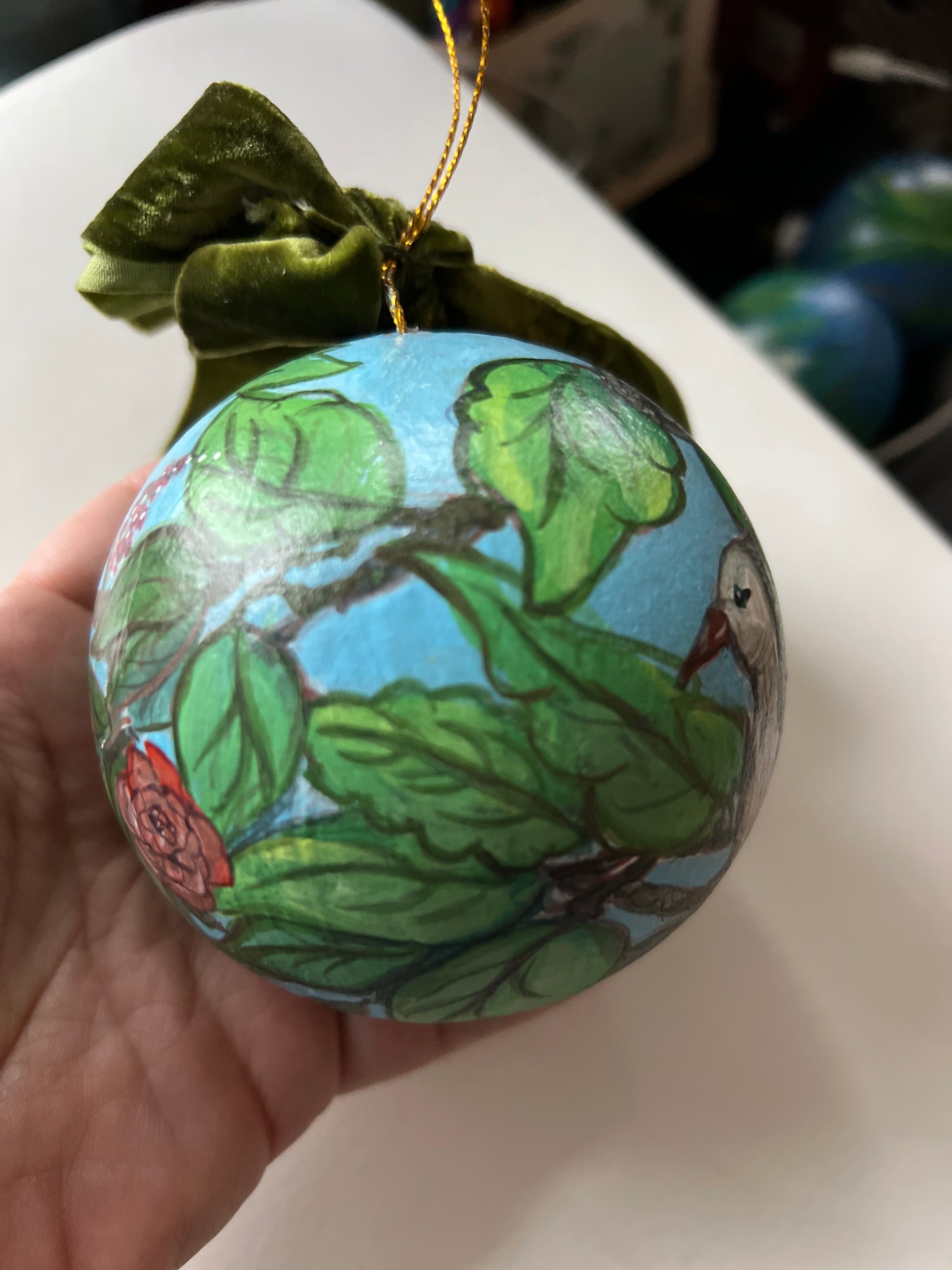 Decorative ornament with nature-themed design held by a hand