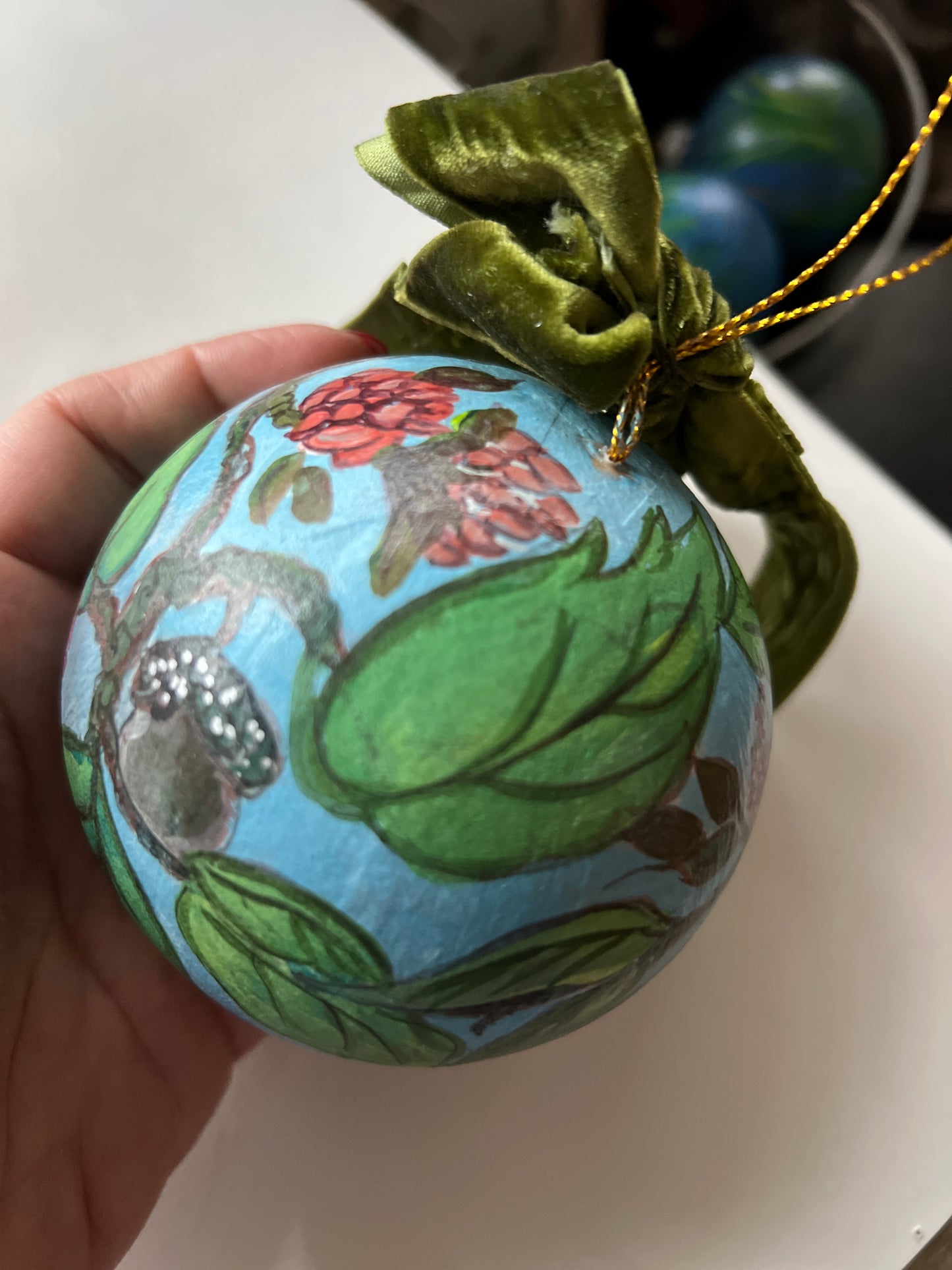 Decorative ornament with floral design held by a hand