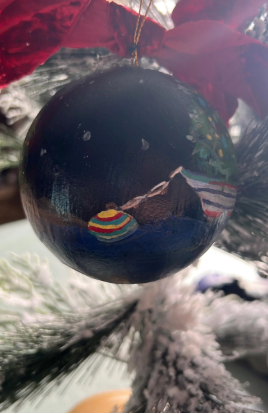 Decorative Christmas ball with a colorful fish design on a blurred background