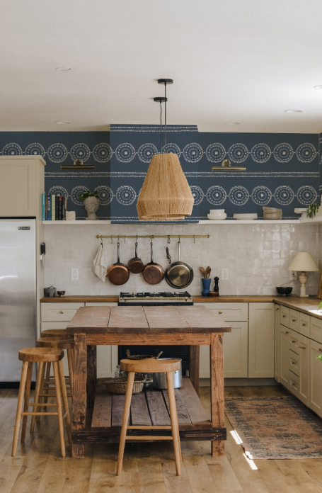 Kitchen with wooden table, stools, and blue patterned wall