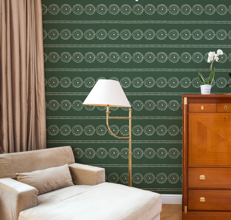Living room with green patterned wallpaper, beige sofa, gold floor lamp, and wooden cabinet.