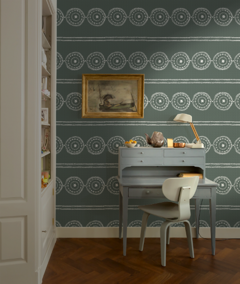 Room interior with a desk, chair, and decorative wall paper.