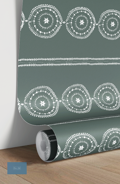 Roll of green wallpaper with white geometric patterns on a wooden surface.