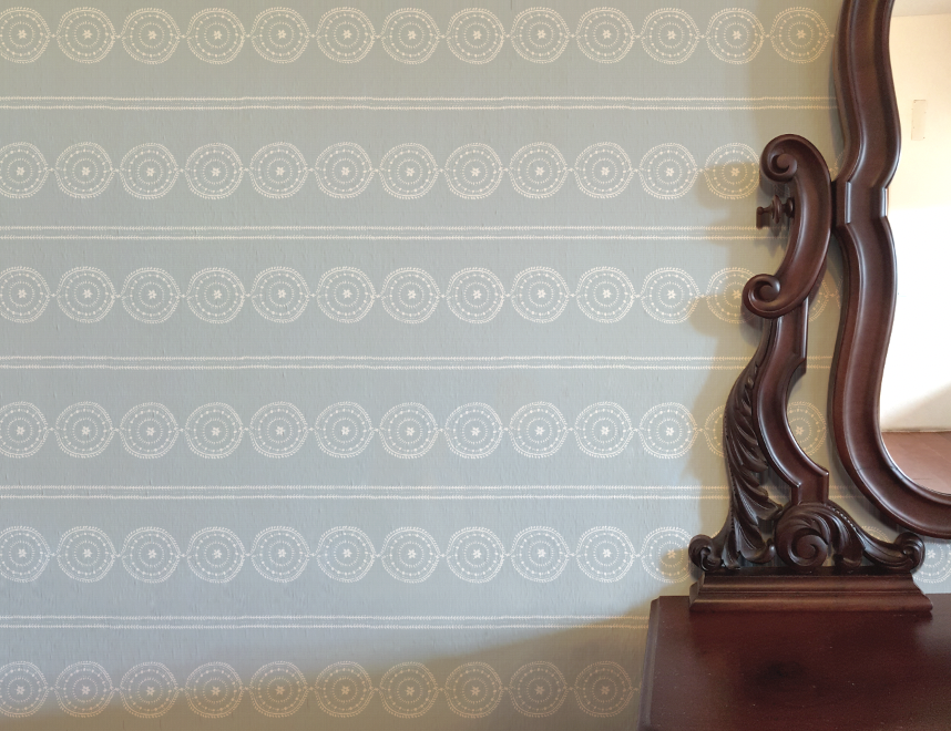 Wooden mirror against a wall with decorative circular patterns