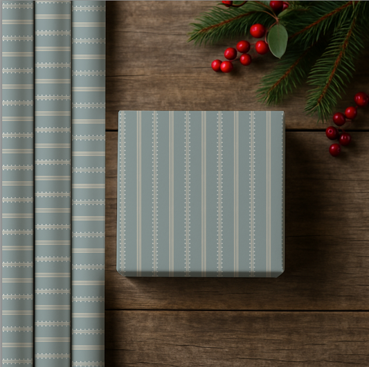 Gift box with blue striped wrapping paper on a wooden surface with Christmas decorations.