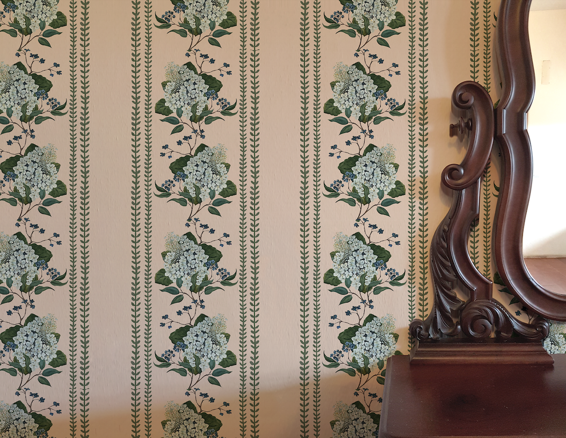 Floral wallpaper with green hydrangeas on a beige background, featuring a wooden mirror.