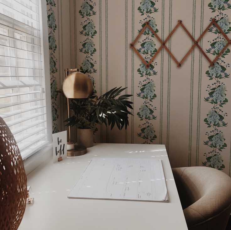 Room interior with a table, plant, and decorative wall art.