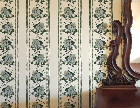 Floral striped wallpaper with a wooden mirror on a white wall