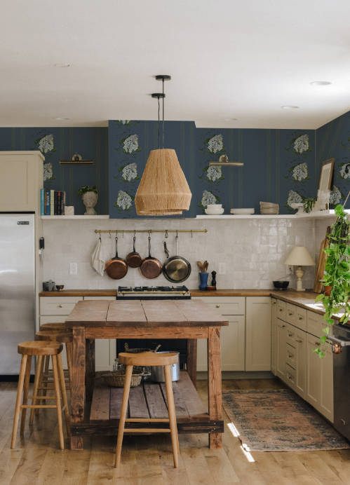 Kitchen with wooden table, stools, and blue wall with leaf pattern