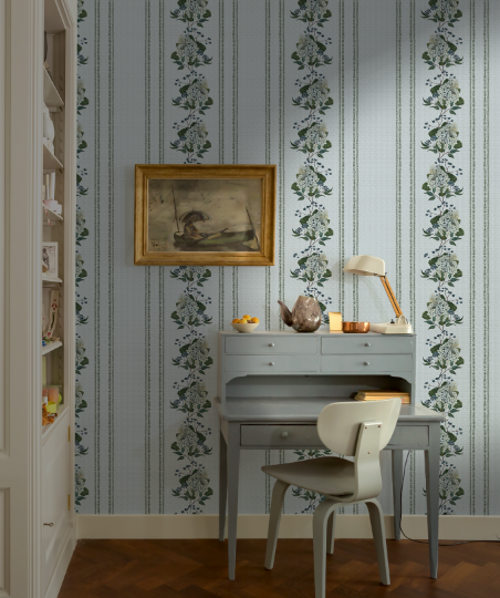 Room interior with floral wallpaper, desk, and chair.