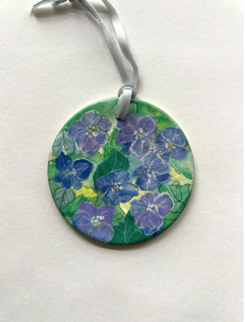 Round pendant with floral design on a white background