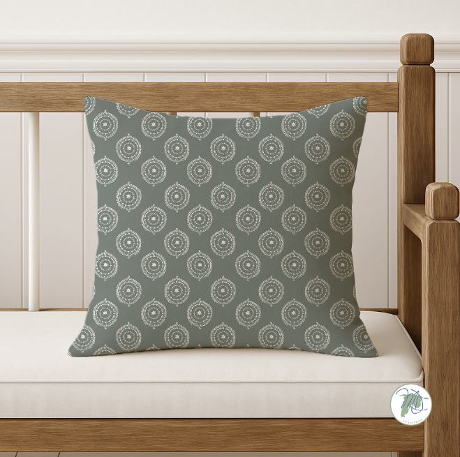 Patterned green pillow on a wooden bench with a white background