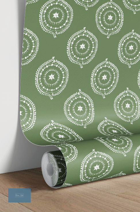 Roll of green wallpaper with white circular pattern on a wooden floor.