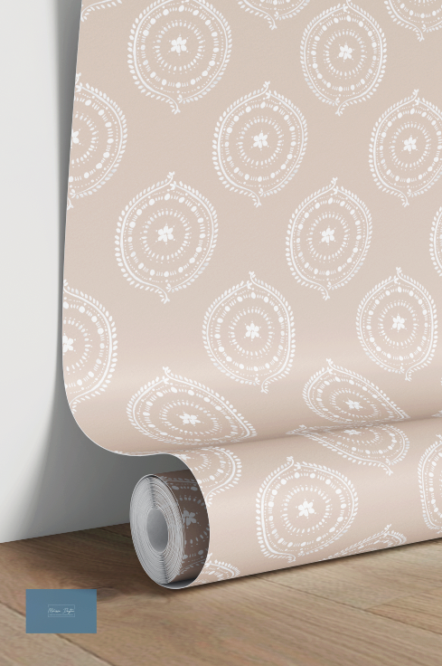 Roll of antique pink wallpaper with white geometric pattern on a wooden surface.