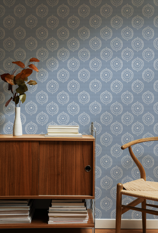 Room interior with wooden cabinet, chair, and patterned wallpaper