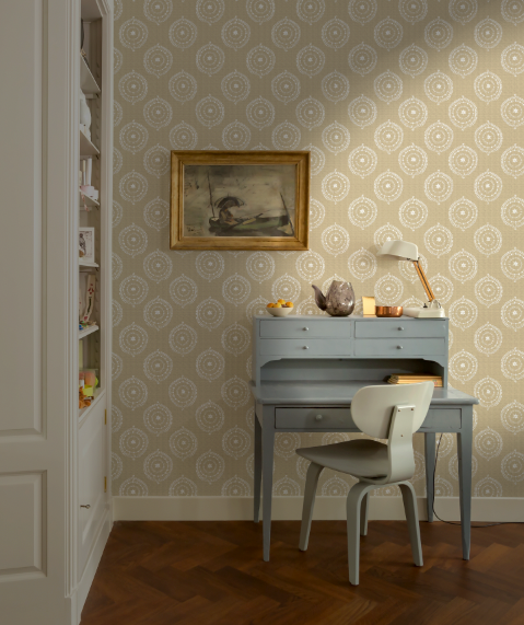 Room interior with a desk, chair, and decorative items against a patterned wall.