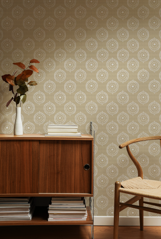 Room interior with wooden cabinet, books, and vase against a patterned wall.