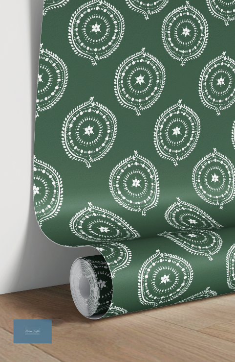Roll of green wallpaper with white decorative patterns on a wooden floor.