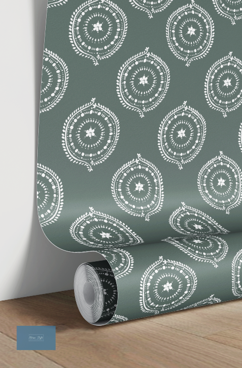 Roll of green wallpaper with white geometric pattern on a wooden floor.