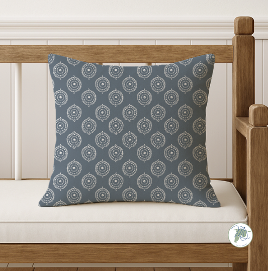 Decorative pillow with a blue pattern on a wooden bench.