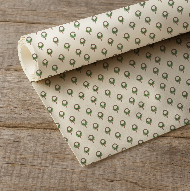 Roll of patterned paper with green designs on a wooden surface