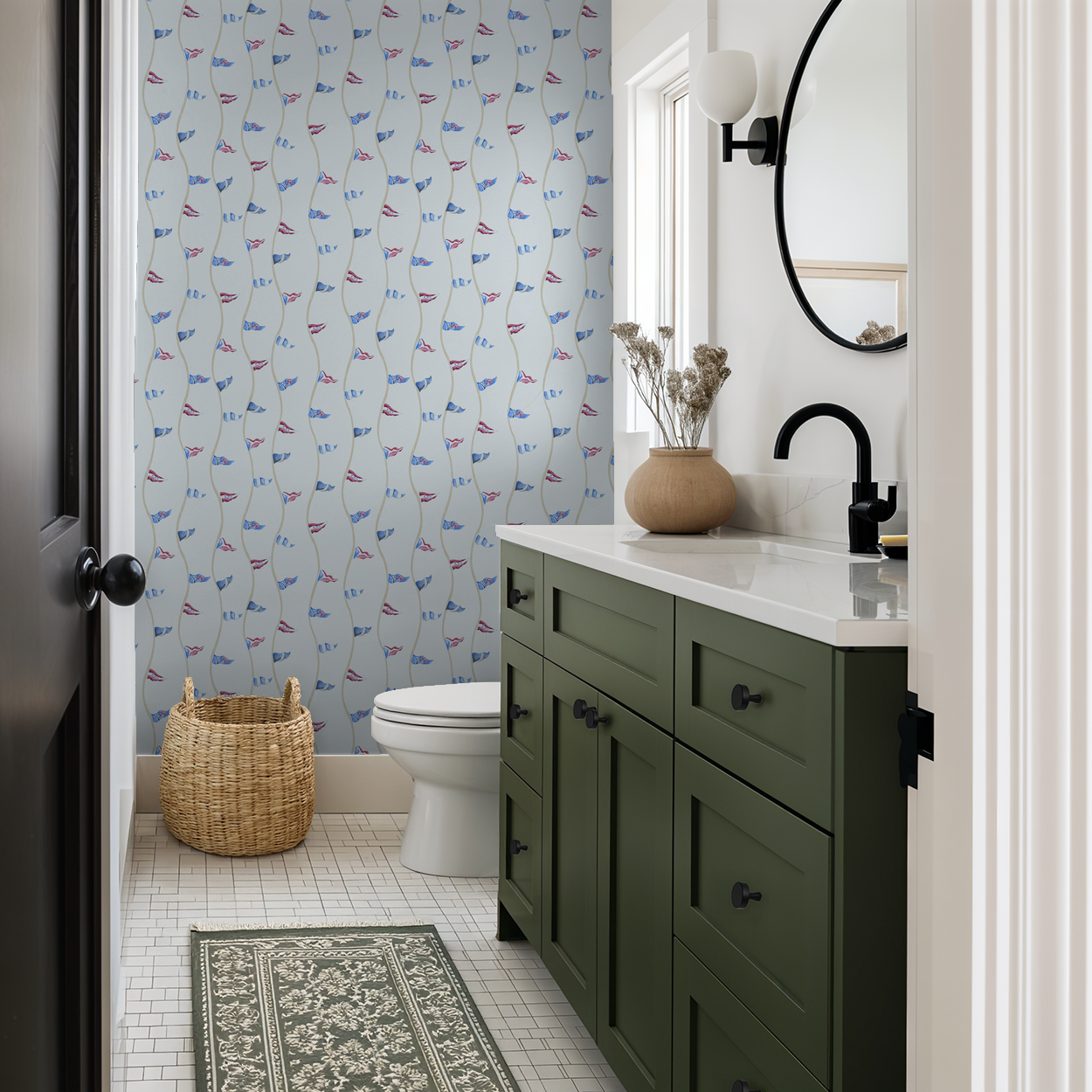 Bathroom with green vanity, toilet, and patterned wallpaper.