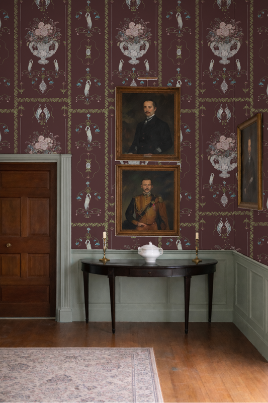 Stately room with ornate wallpaper, portraits, and a console table.